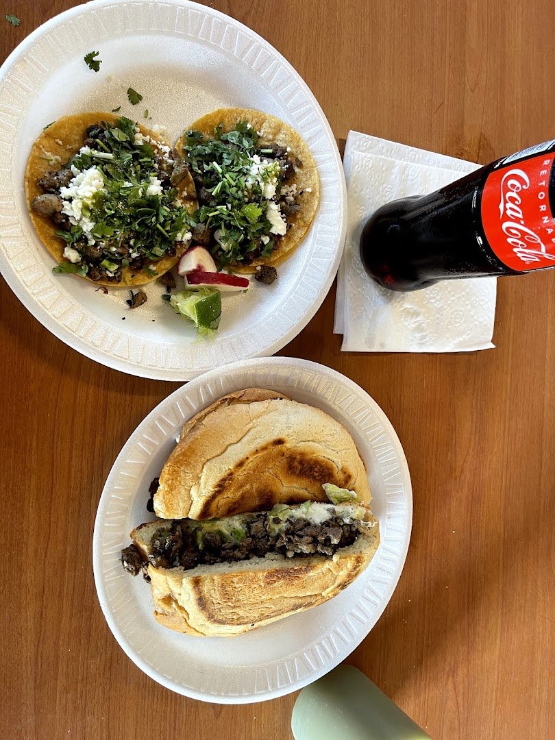 Plates of tacos and tamales on a restaurant table.